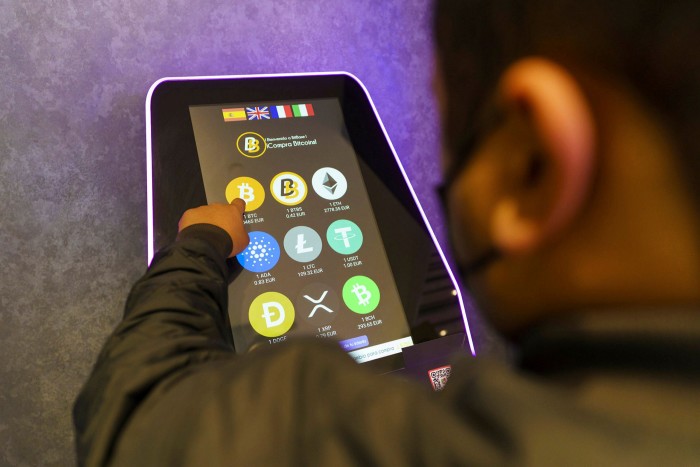 A customer uses a cryptocurrency ATM at a shopping centre in Madrid, Spain