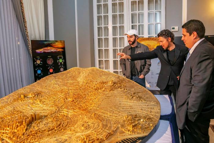 Nayib Bukele, El Salvador’s president, left, with his golden scale model of a planned crypto-funded Bitcoin City