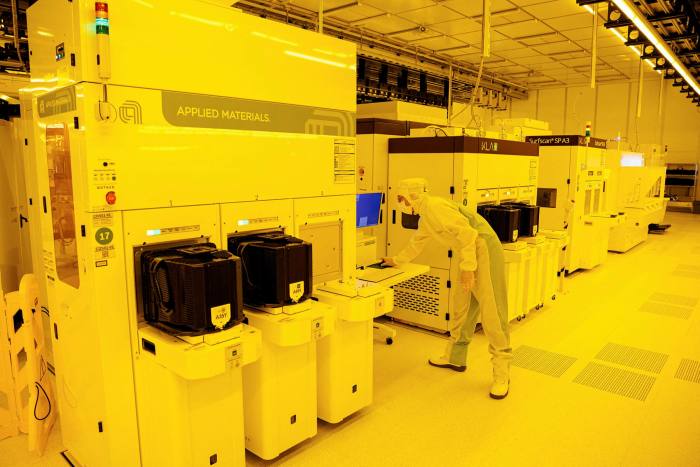 An employee works at a machine for structure inspection and quality control of 300-millimeter wafers in the production of semiconductor chips on the production line at the Bosch semiconductor plant in Dresden, eastern Germany